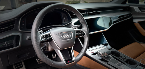Luxury Car interior. Dashboard, steering wheele, gear stick can be seen.